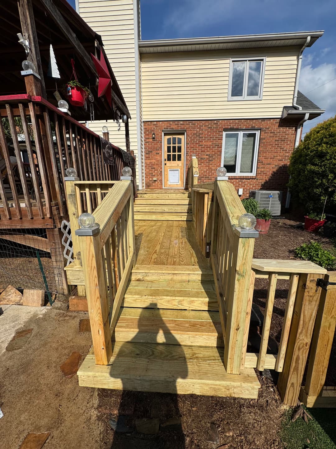 New wooden ramp with railings leading to a house, ideal for accessibility and outdoor design.